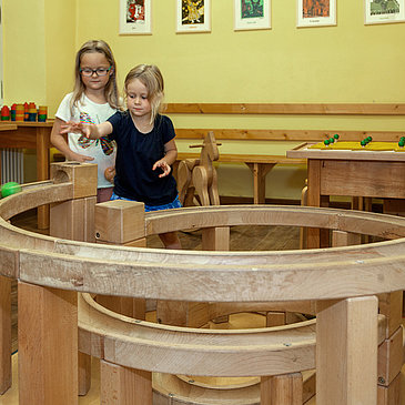 Das Bild zeigt zwei Mädchen, die mit einer Kugelbahn im Spielzimmer des Hunsrücker Holzmuseums spielen.