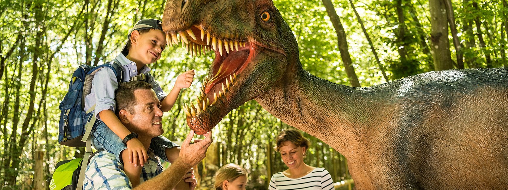 Das Bild zeigt eine Familie im Dinopark Teufelsschlucht.
