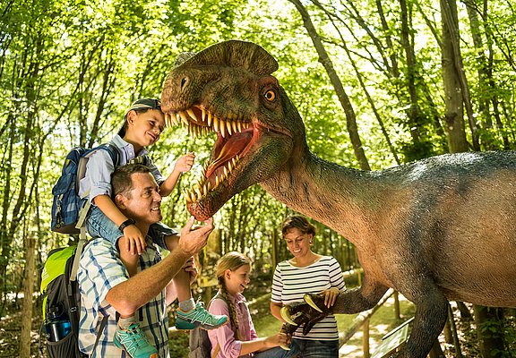 Das Bild zeigt eine Familie im Dinopark Teufelsschlucht.
